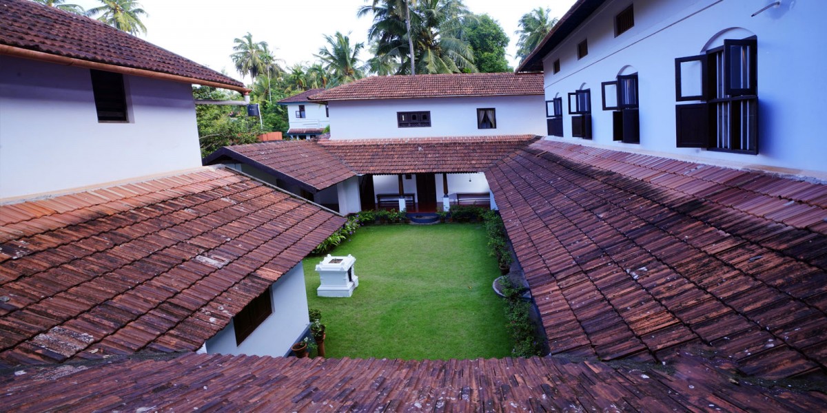 Aerial view of Harivihar — the terracotta-tiled roofs of the four wings enclosing the green central courtyard